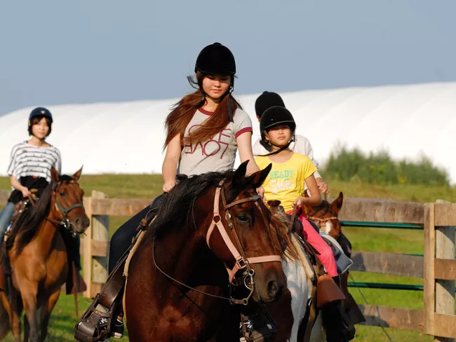 Three girls riding horses.